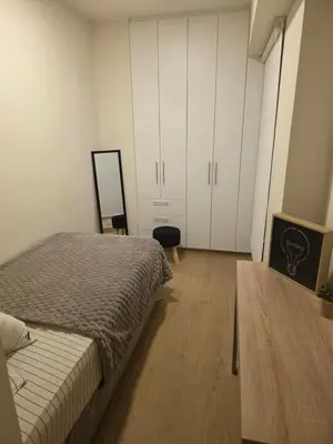 a bedroom with a bed and a table and cabinets at Habitación en Apartamento Pueblo Libre in Lima