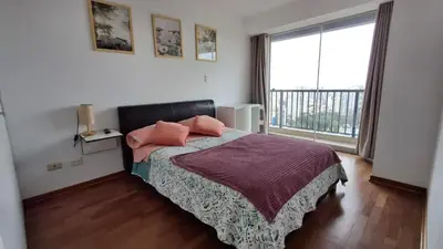 a bedroom with a bed and a large window at Amplio, céntrico, buena vista in Lima