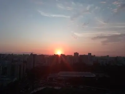 a sun setting over a city with tall buildings at Amplio, céntrico, buena vista in Lima