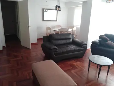 a living room with a couch and a table at Amplio, céntrico, buena vista in Lima