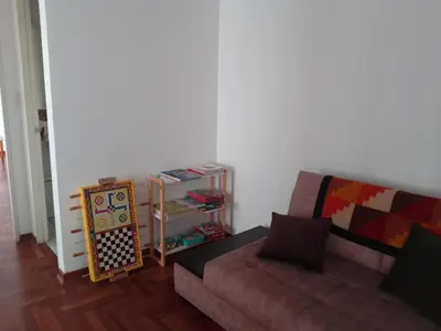 a living room with a couch and a book shelf at Amplio, céntrico, buena vista in Lima