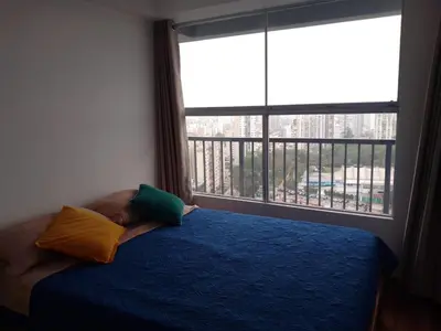 a bedroom with a blue bed and a large window at Amplio, céntrico, buena vista in Lima