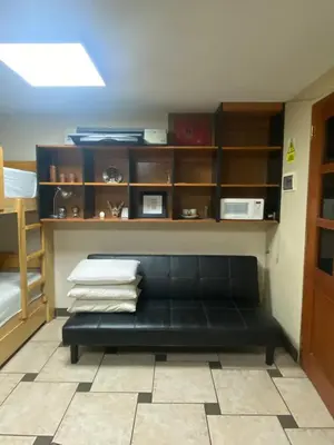 a black couch in a room with shelves at Mini Supercentrico in Lima