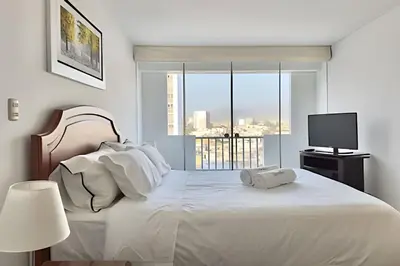 a white bedroom with a large bed with a window at Big 3BR Apartment in the center of Miraflores in Lima