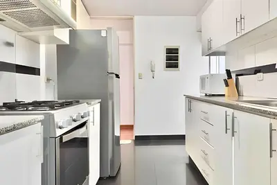 a kitchen with white cabinets and a stainless steel refrigerator at Big 3BR Apartment in the center of Miraflores in Lima