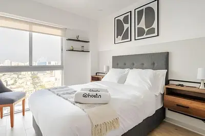 a bedroom with a white bed with a chair and a window at Contemporary Great View in Lima