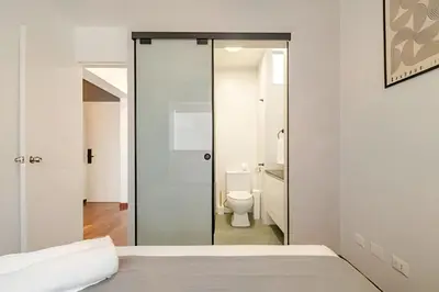 a bedroom with a glass door leading to a toilet at Exclusive Apartment in Miraflores in Lima
