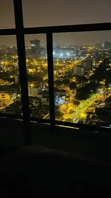a view of a city at night from a window at Piso 25 con vista panorámica in Lima
