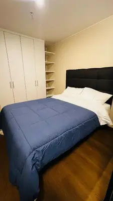 a bedroom with a large bed with a blue blanket at Piso 25 con vista panorámica in Lima