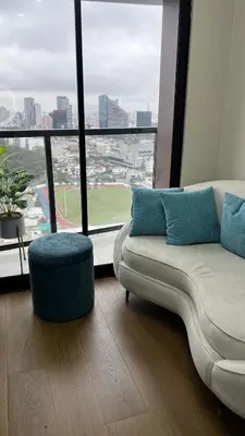 a living room with a couch and a large window at Piso 25 con vista panorámica in Lima