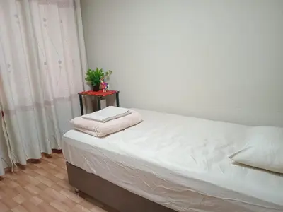 a bedroom with a bed with a nightstand next to a window at Habitación Estandar con baño privado en Monterrico Sur in Lima