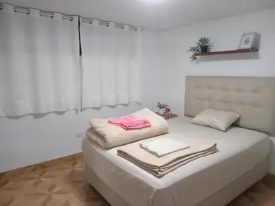 a white room with a bed with towels on it at Habitación Estandar con baño privado en Monterrico Sur in Lima
