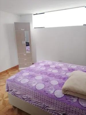 a bedroom with a purple bed and a mirror at Habitación Estandar con baño privado en Monterrico Sur in Lima