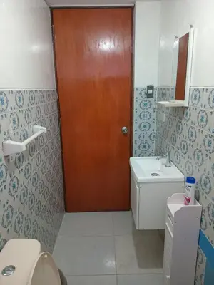 a bathroom with a toilet and a wooden door at Habitación Estandar con baño privado en Monterrico Sur in Lima