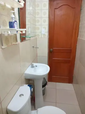 a bathroom with a white toilet and a sink at Habitación Estandar con baño privado en Monterrico Sur in Lima