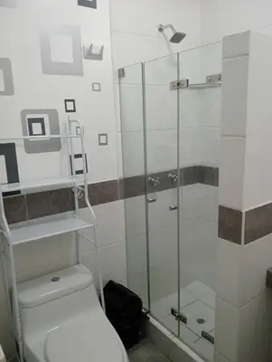 a bathroom with a toilet and a glass shower at Apartment in the center of Miraflores in Lima