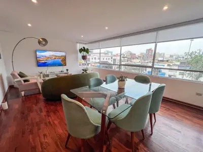 a living room with a glass table and chairs at LimaViva A in Lima