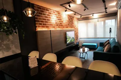 a dining room with a brick wall and a table and chairs at iStay 1bed 1Bathroom Urban Deluxe in Lima