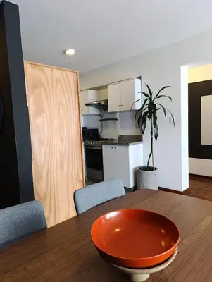 an orange bowl on a wooden table in a kitchen at iStay 2D a 1 cuadra del Malecon in Lima