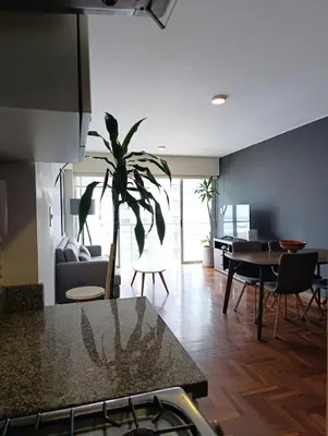 a living room with a table and a palm tree in it at iStay 2D a 1 cuadra del Malecon in Lima