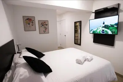 a bedroom with a white bed and a flat screen tv at iStay Atractivo corazón de Miraflores 2 Camas 2 Baños in Lima