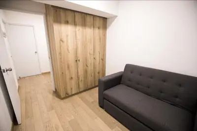 a living room with a couch and a wooden door at iStay Atractivo corazón de Miraflores 2 Camas 2 Baños in Lima