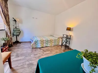 a room with a bed and a green table at Casa Cubo Deluxe in La Molina in Lima