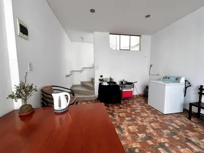 a living room with a table and stairs in it at Casa Cubo Deluxe in La Molina in Lima
