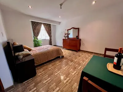 a bedroom with a bed and a dresser and a mirror at Casa Cubo Deluxe in La Molina in Lima