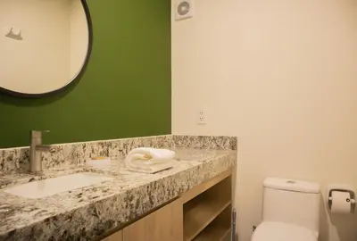 a bathroom with a sink and a mirror and a toilet at Palma Suites by Wynwood House in Lima