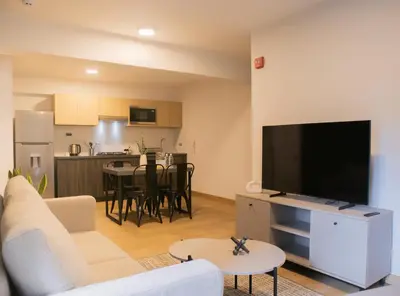 a living room with a couch and a flat screen tv at Palma Suites by Wynwood House in Lima