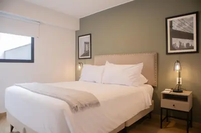 a bedroom with a large bed with white pillows at Palma Suites by Wynwood House in Lima