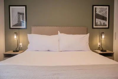 a bedroom with a bed with white pillows and two lamps at Palma Suites by Wynwood House in Lima