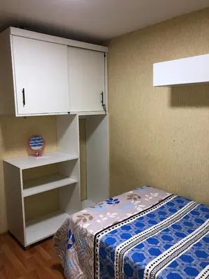 a bedroom with a bed and a white cabinet at Departamento Condominio Club Carabayllo in Carabayllo