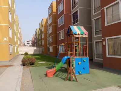a playground in front of a apartment building at Departamento Condominio Club Carabayllo in Carabayllo
