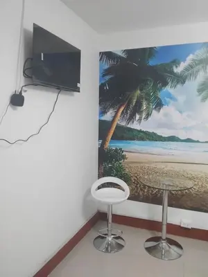 a room with a table and a tv and a stool at Habitación acogedora in Lima