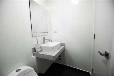 a bathroom with a sink and a toilet and a mirror at iStay Encantador Loft Piscina BBQ Gym Bicicleta in Lima
