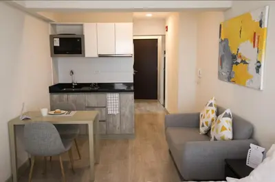 a living room with a couch and a table and a kitchen at iStay Encantador Loft Piscina BBQ Gym Bicicleta in Lima