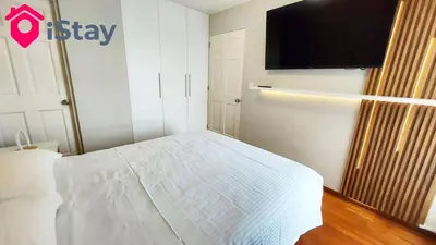 a bedroom with a bed and a flat screen tv at iStay Espectacular Vista Mar Miraflores in Lima