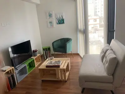 a living room with a couch and a tv and a table at iStay Santuario Linsidro Cerca Hospitales Gym in Lima