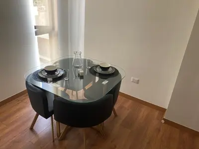 a dining room table with two chairs and a glass table at iStay Santuario Linsidro Cerca Hospitales Gym in Lima