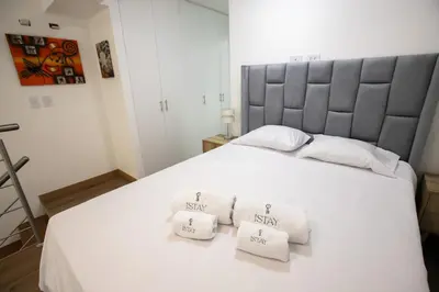 a bedroom with a large white bed with three white towels at Mezanine Deluxe Miraflores in Lima