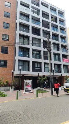 a woman walking in front of a large building at Mezanine Deluxe Miraflores in Lima