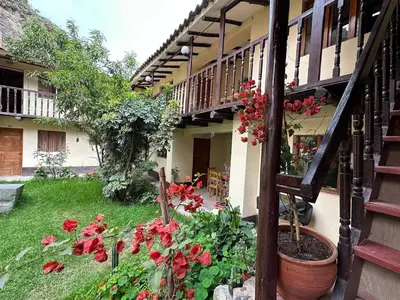 a garden with red flowers and a staircase at Casa Paqocha Garden - Ollantaytambo - Hot Water - Wifi - Cocina Compartida in Ollantaytambo