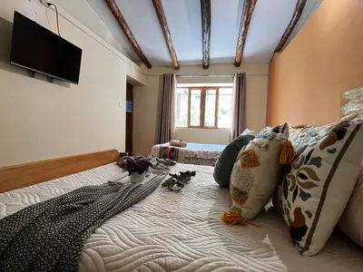 a bedroom with a large bed with pillows at Casa Paqocha Garden - Ollantaytambo - Hot Water - Wifi - Cocina Compartida in Ollantaytambo