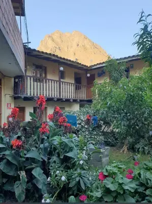 a building with a bunch of flowers in front of it at Casa Paqocha Garden - Ollantaytambo - Hot Water - Wifi - Cocina Compartida in Ollantaytambo