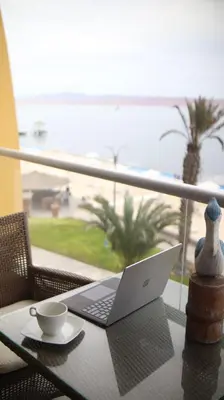 a laptop on a table with a view of the beach at PARACAS Sotavento T2 401 in Paracas