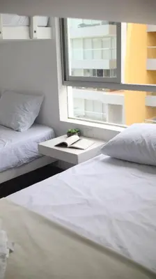 a bedroom with two beds and a window at PARACAS Sotavento T2 401 in Paracas