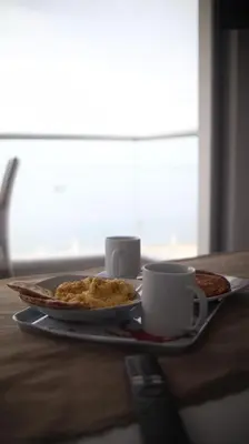 a table with a plate of food and cups on it at PARACAS Sotavento T2 401 in Paracas