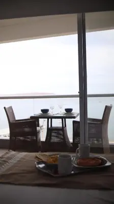a table with a plate of food and two glasses at PARACAS Sotavento T2 401 in Paracas